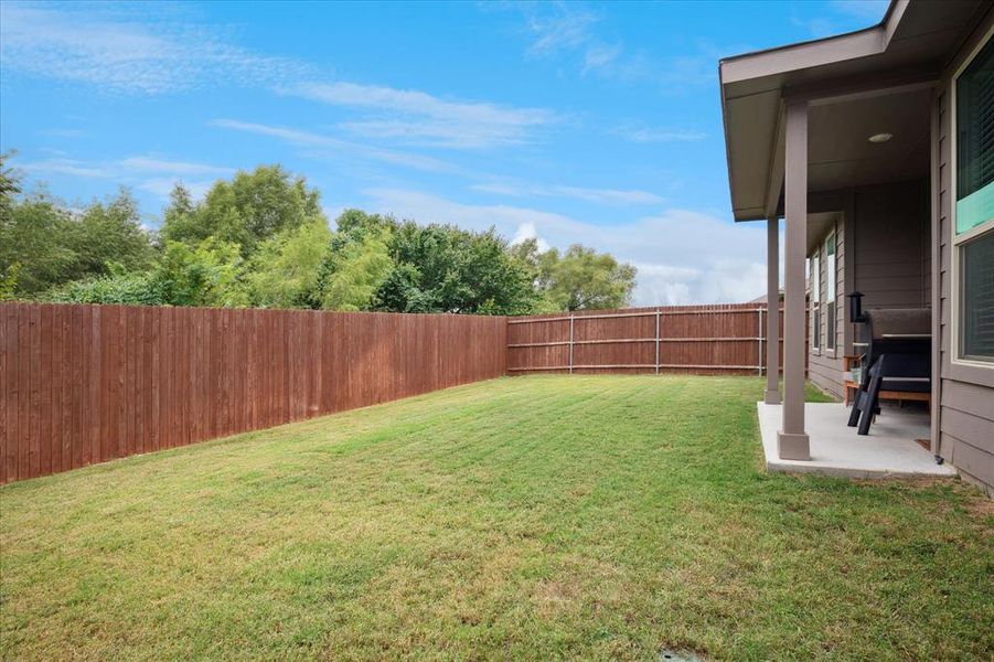 Fenced backyard featuring a covered patio area. Fenced backyard featuring a covered patio area.