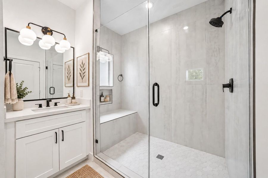 Primary Bath. Separate vanities and walk in shower with floor to ceiling tile surround.