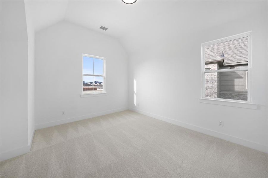 Additional living space featuring light carpet and lofted ceiling