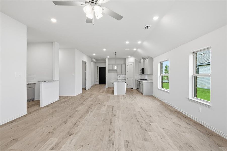 Open-concept living space featuring wood-finish flooring, recessed lighting, and a ceiling fan Open-concept living space featuring wood-finish flooring, recessed lighting, and a ceiling fan