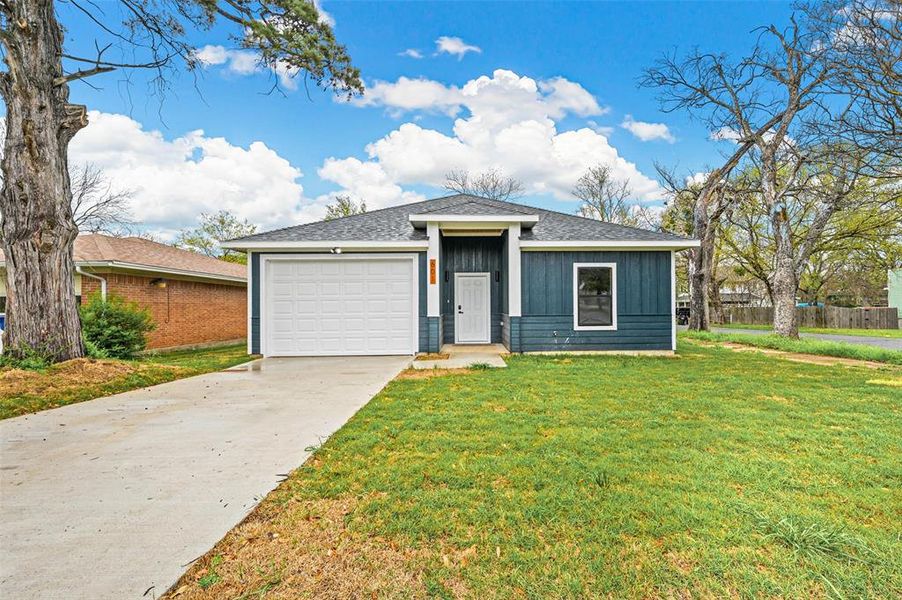 View of front of home featuring a garage and a front lawn