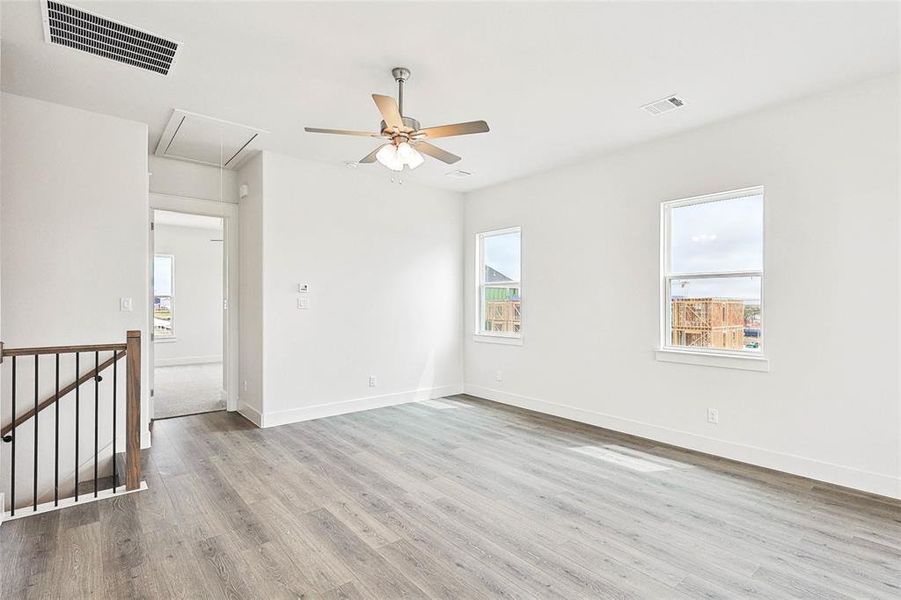 Unfurnished room featuring wood-type flooring, a wealth of natural light, and ceiling fan