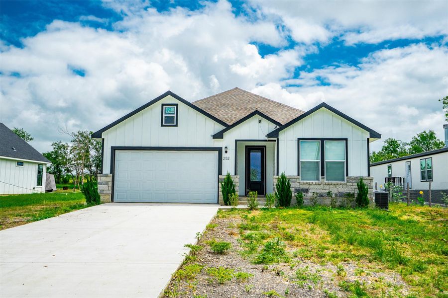 A newly constructed modern home awaits with a crisp white exterior, stone accents, and an integrated garage. A newly constructed modern home awaits with a crisp white exterior, stone accents, and an integrated garage.
