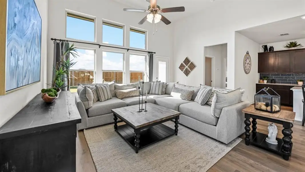 Spacious living area featuring high ceilings, a ceiling fan, and extensive natural light from multiple windows