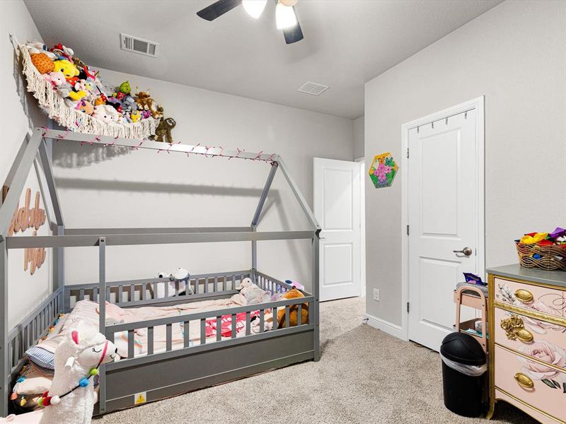 Carpeted bedroom featuring ceiling fan