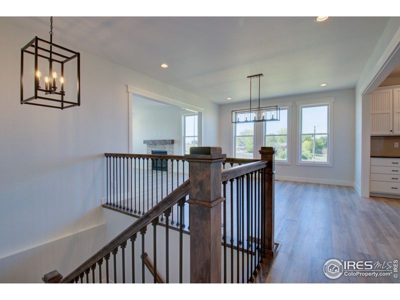 Beautiful, stained maple banisters and wrought iron balusters create an elegant staircase to the garden level below