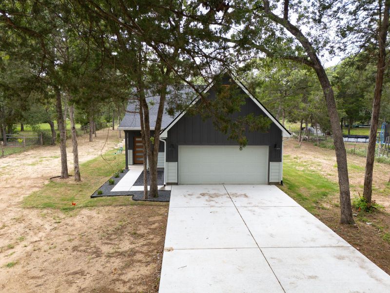 A stunning front view of a beautifully designed home with spacious parking, nestled on nearly an acre of land. A stunning front view of a beautifully designed home with spacious parking, nestled on nearly an acre of land.