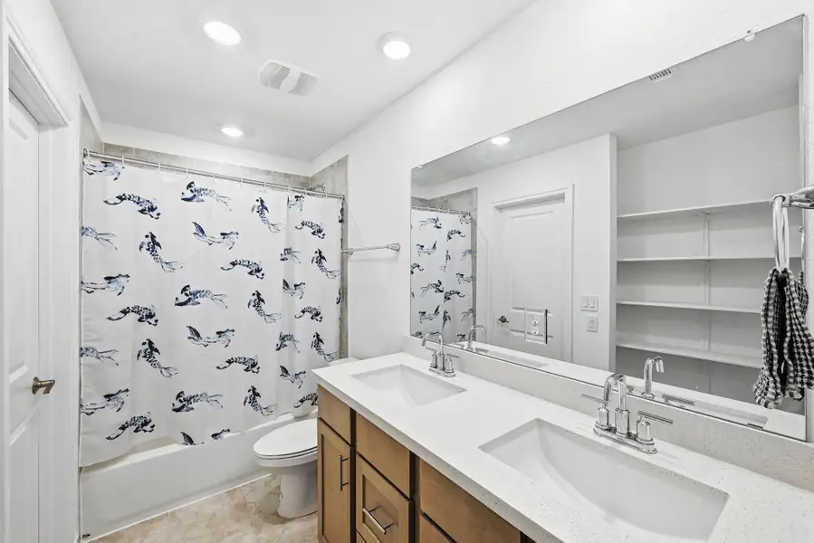 Full bathroom with double vanity and shower / bathtub combination with curtain