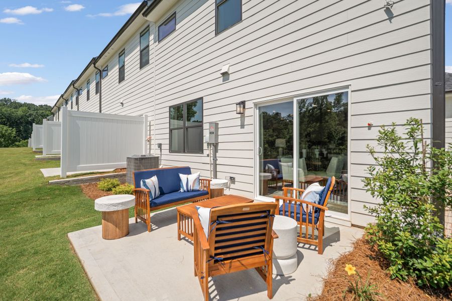 A patio with chairs and a table outside of a house.