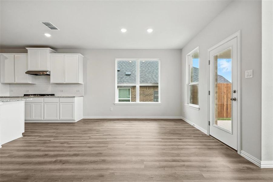 Kitchen featuring gas cooktop, plenty of natural light, white cabinets, tasteful backsplash, and recessed lighting Kitchen featuring gas cooktop, plenty of natural light, white cabinets, tasteful backsplash, and recessed lighting