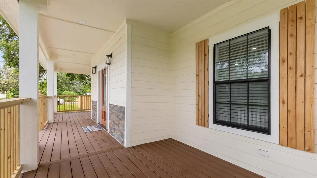Enjoy a warm welcome every day on this charming front porch. The elegant glass-paneled front door is framed by two classic lantern-style sconces and accented with a stone veneer entry.
