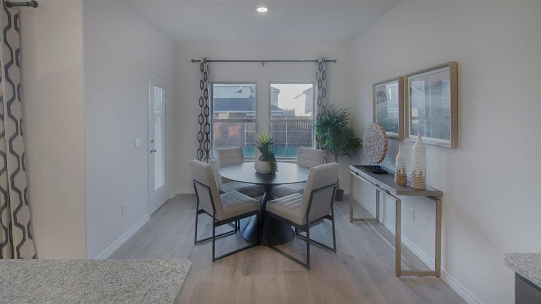 Dining area featuring wood-finish flooring, recessed lighting, and a glass-paneled exterior door Dining area featuring wood-finish flooring, recessed lighting, and a glass-paneled exterior door