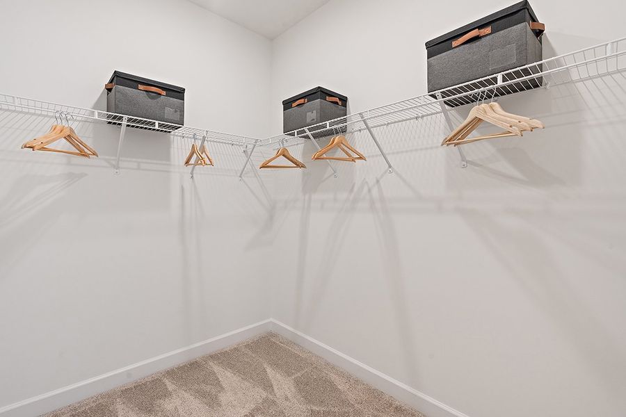 A white wall with a few wooden benches and a few black boxes. A white wall with a few wooden benches and a few black boxes.