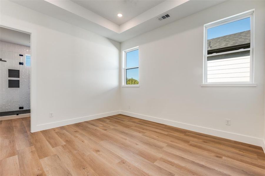 Spare room featuring healthy amount of natural light, light wood-style flooring, and recessed lighting