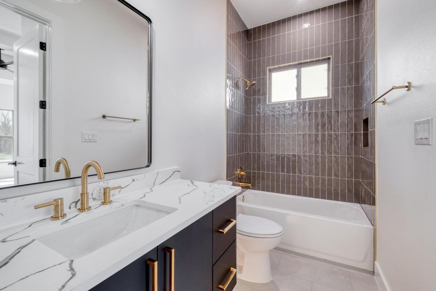 Bathroom featuring shower / bathing tub combination, toilet, vanity, and tile patterned flooring