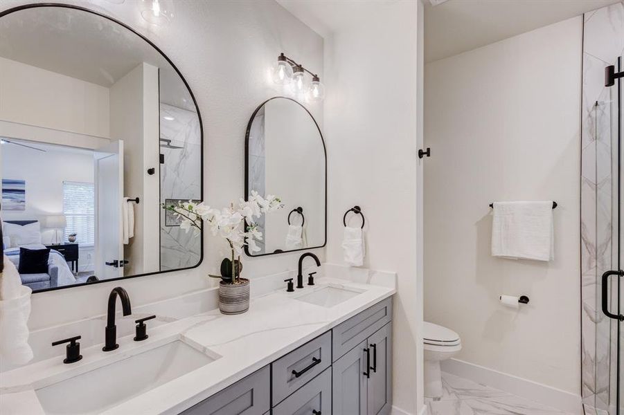 Bathroom featuring vanity, toilet, and an enclosed shower