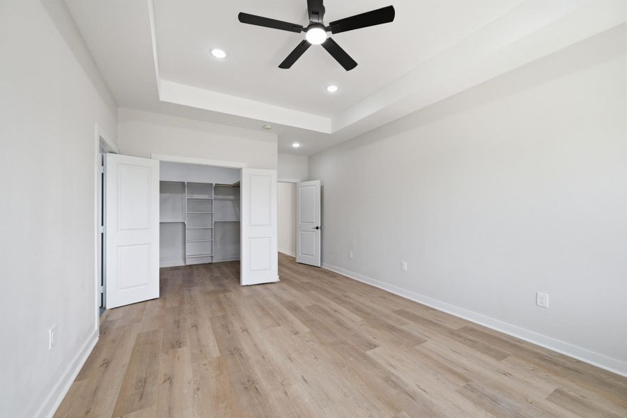 Primary bedroom with tray ceiling & walk-in closet Primary bedroom with tray ceiling & walk-in closet