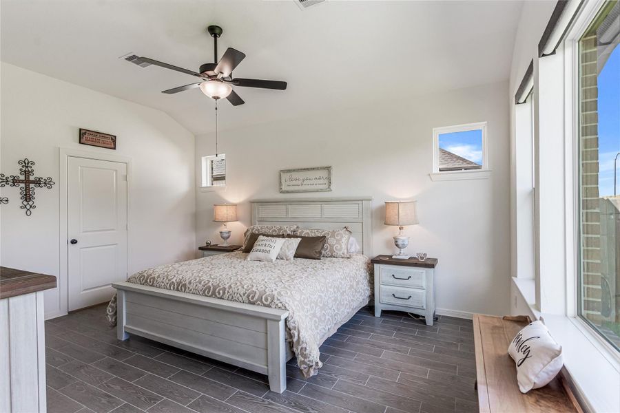 Charming primary bedroom with abundant natural light, perfectly fitting a king size bed and perfect for relaxation.