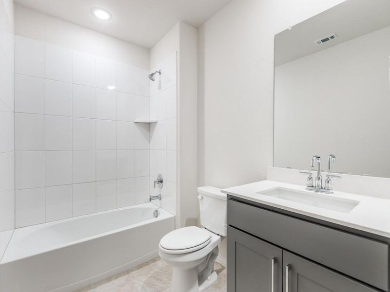 Bathroom with shower / washtub combination, vanity, and light tile patterned floors