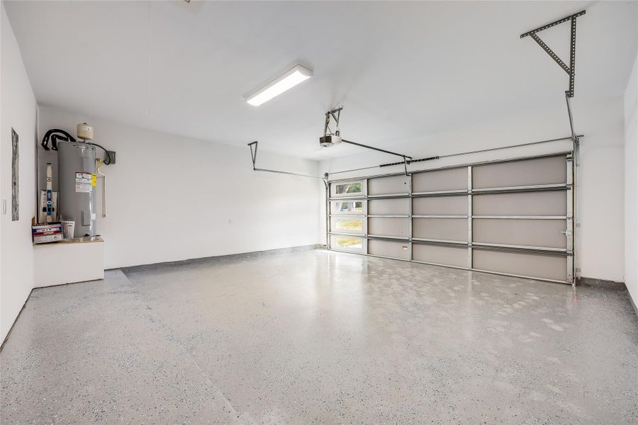 Garage featuring water heater and a garage door opener Garage featuring water heater and a garage door opener