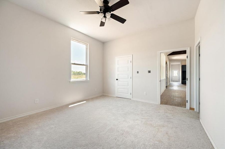 Unfurnished bedroom with light carpet and ceiling fan