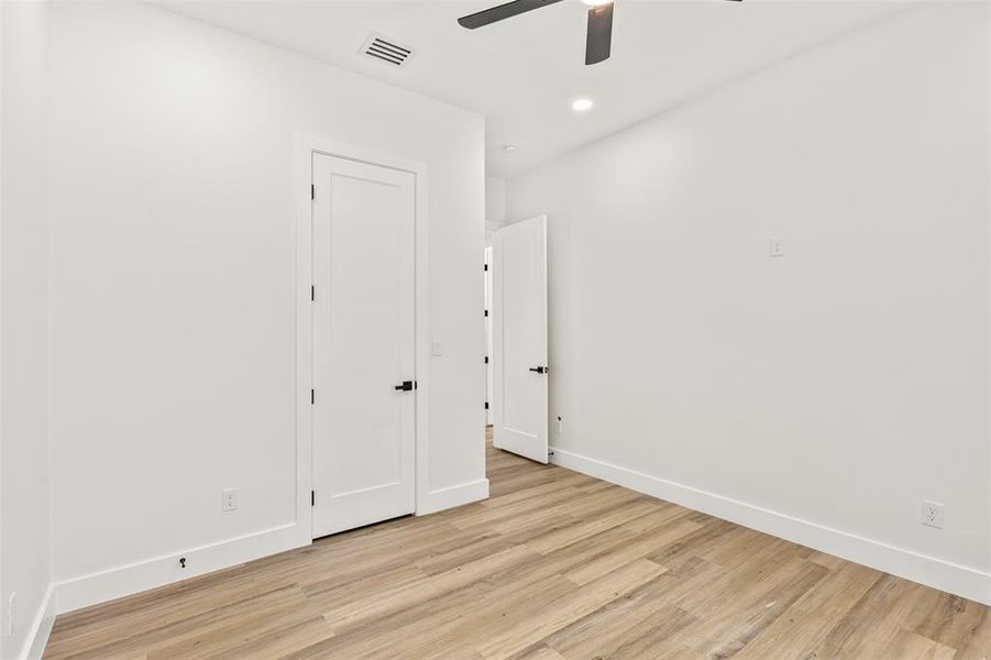 Room featuring wood-finish flooring, white baseboards, and white walls