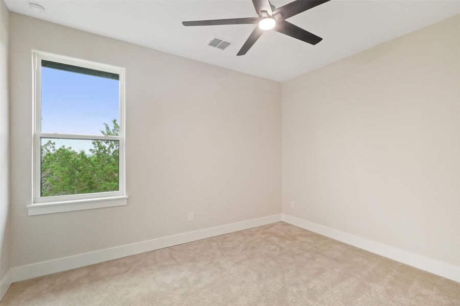 Carpeted spare room featuring visible vents, ceiling fan, and baseboards Carpeted spare room featuring visible vents, ceiling fan, and baseboards