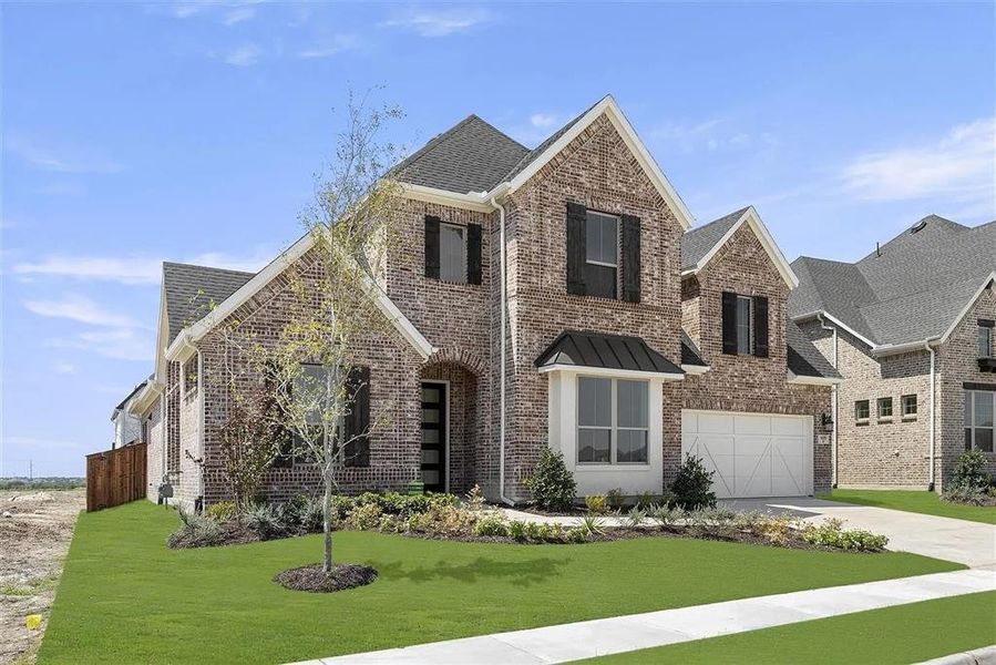 View of front facade featuring a front lawn and a garage