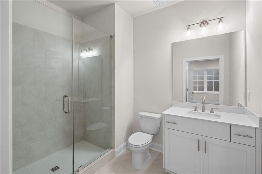 Full bathroom featuring vanity, a stall shower, and light tile patterned floors