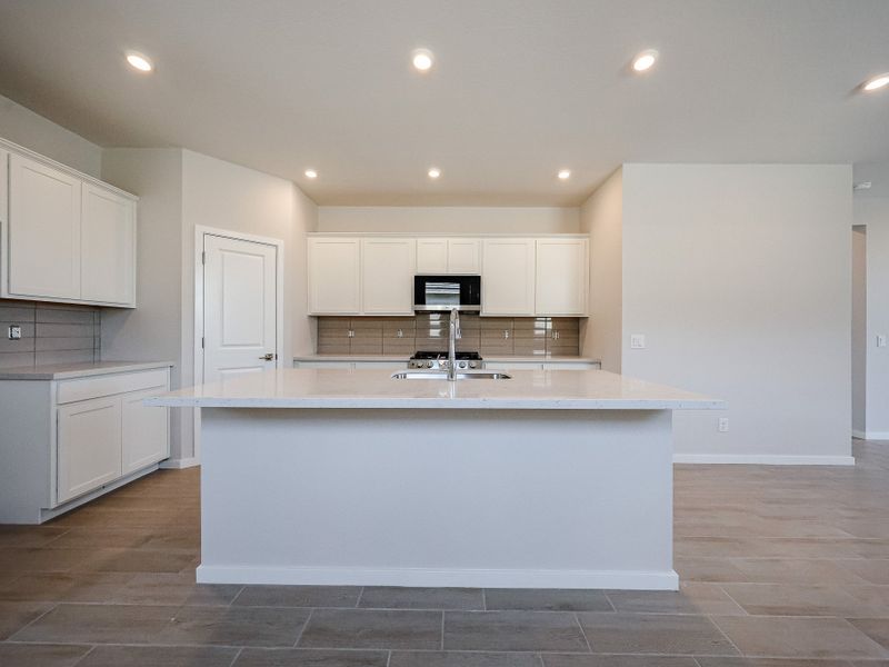 A kitchen with white cabinets.