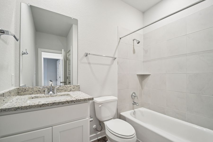 A bathroom with a tub sink and toilet.