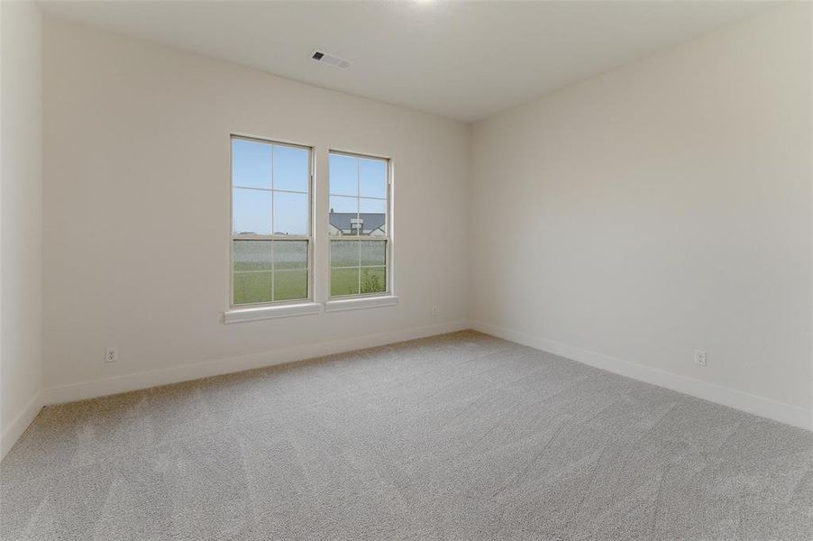 Room featuring two large windows with white trim, light gray carpet, white baseboards, and light neutral walls Room featuring two large windows with white trim, light gray carpet, white baseboards, and light neutral walls
