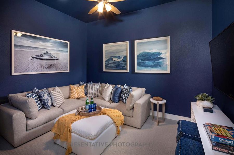 Carpeted living area featuring a ceiling fan and baseboards Carpeted living area featuring a ceiling fan and baseboards