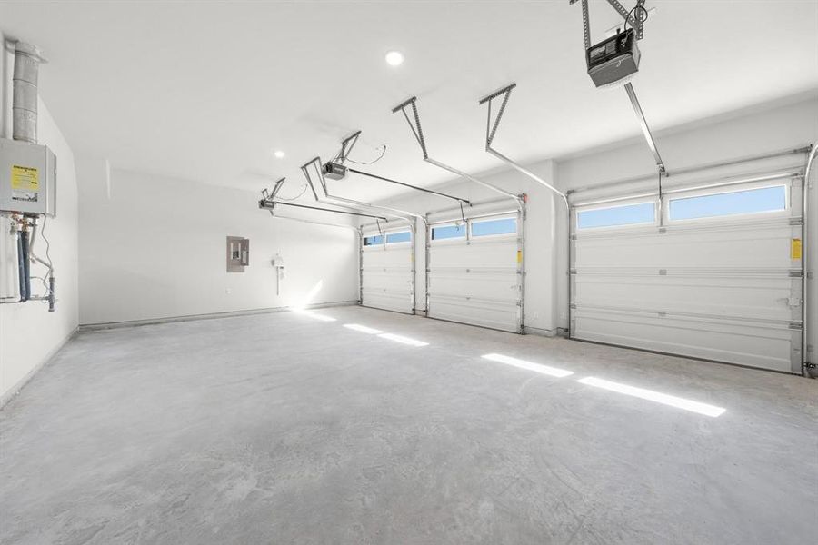 3-car Garage with a garage door openers, electric panel, tankless water heater, and recessed lighting