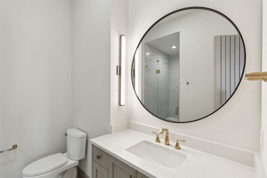 Bathroom with a tile shower, vanity, and toilet