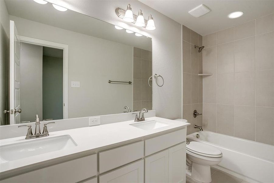 Full bathroom featuring double vanity and shower / tub combination Full bathroom featuring double vanity and shower / tub combination