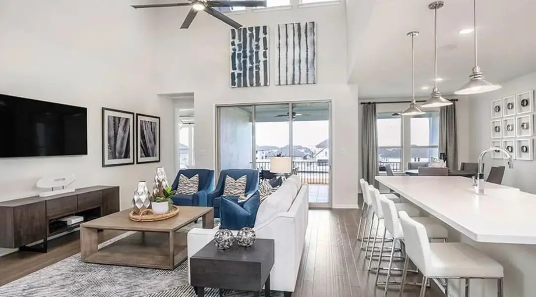 Living area featuring dark wood-type flooring, recessed lighting, a ceiling fan, and a towering ceiling