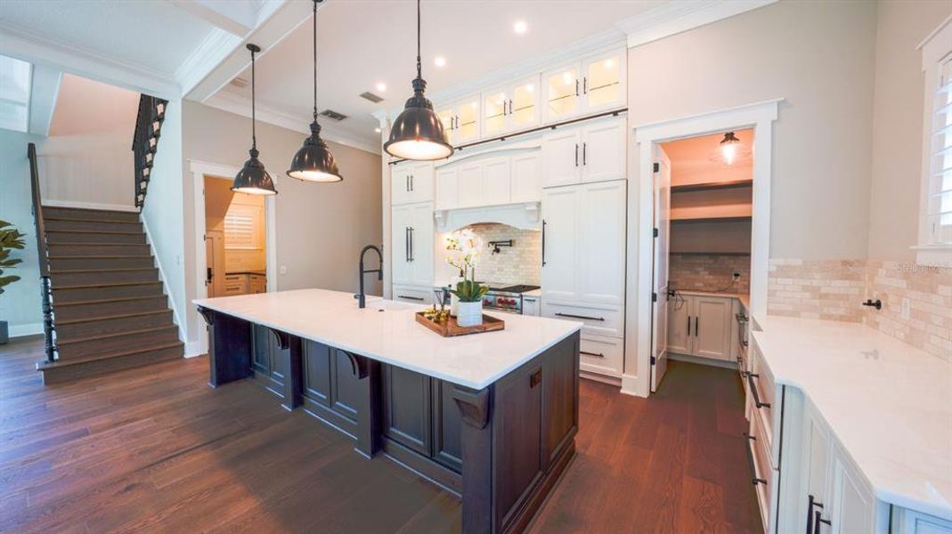 Kitchen with white marble counters and water filtration for coffee bar on side counter