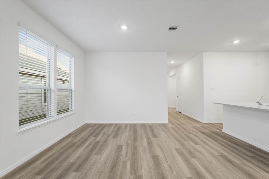 Start your day with a warm cup of coffee and quality time in this charming dining area! Highlights include large window with blinds, custom neutral paint, vinyl plank flooring, recessed lighting and high ceilings.