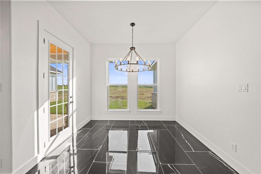 Unfurnished dining area featuring a chandelier, healthy amount of natural light, and baseboards Unfurnished dining area featuring a chandelier, healthy amount of natural light, and baseboards
