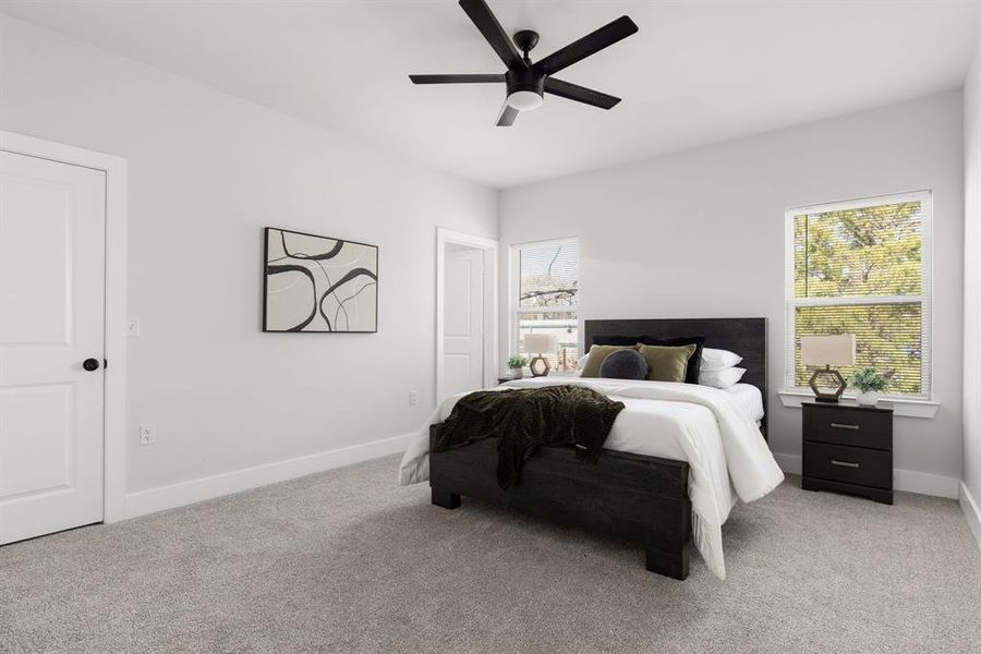 Bedroom with light carpet, a ceiling fan, and baseboards