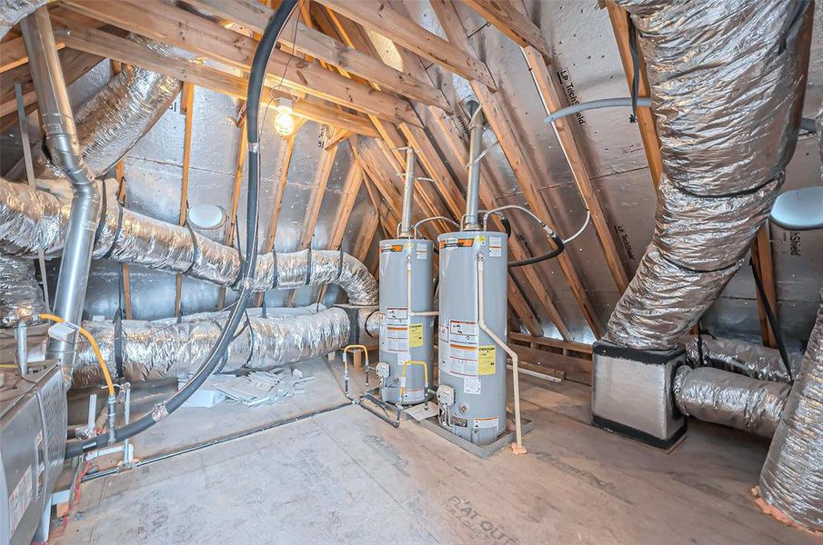 This spacious attic utility area boasts two water heaters and extensive ductwork, with exposed wooden beams and insulation highlighting its excellent maintenance for HVAC and plumbing.
