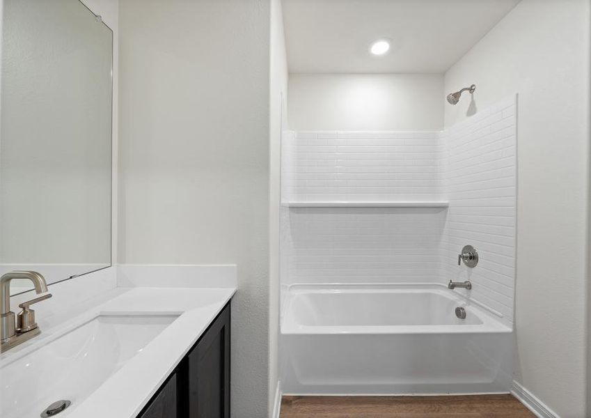 The secondary bathroom has a large vanity space and a shower-tub combo.