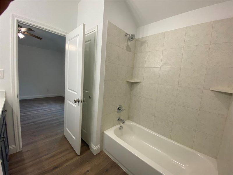 Full bathroom with bathtub / shower combination, dark wood-type flooring, and vanity Full bathroom with bathtub / shower combination, dark wood-type flooring, and vanity