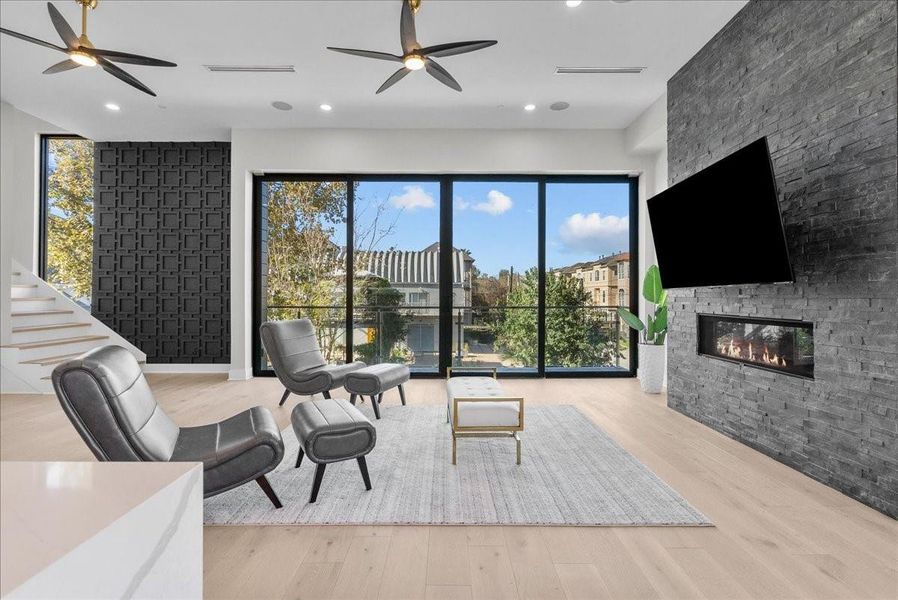 Introducing an oversized living room anchored by a beautiful stone-accented fireplace and opening to a large balcony with expansive decking — creating a seamless indoor-outdoor feel with stunning details throughout. Introducing an oversized living room anchored by a beautiful stone-accented fireplace and opening to a large balcony with expansive decking — creating a seamless indoor-outdoor feel with stunning details throughout.