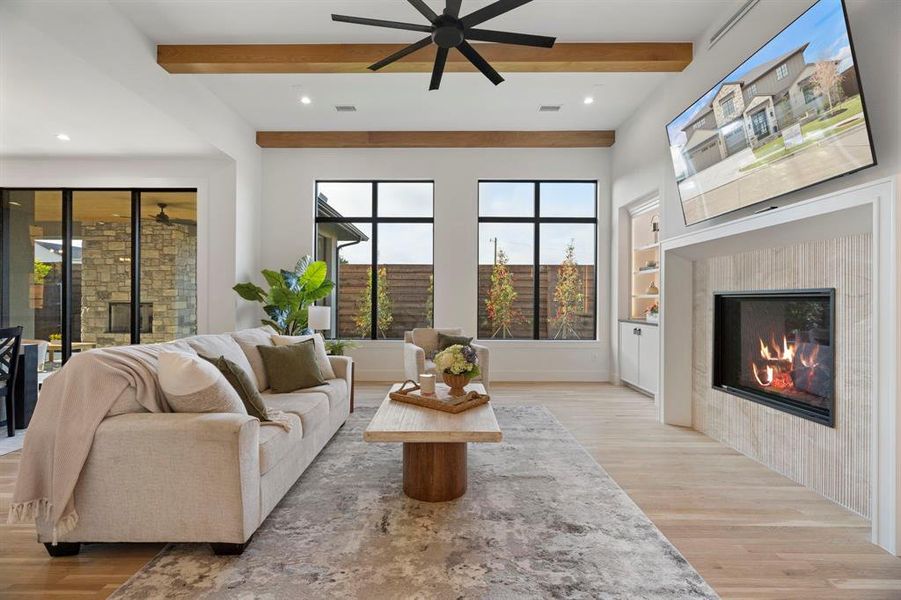 Living area featuring a tile fireplace, recessed lighting, light wood-type flooring, built in shelves, and a ceiling fan Living area featuring a tile fireplace, recessed lighting, light wood-type flooring, built in shelves, and a ceiling fan
