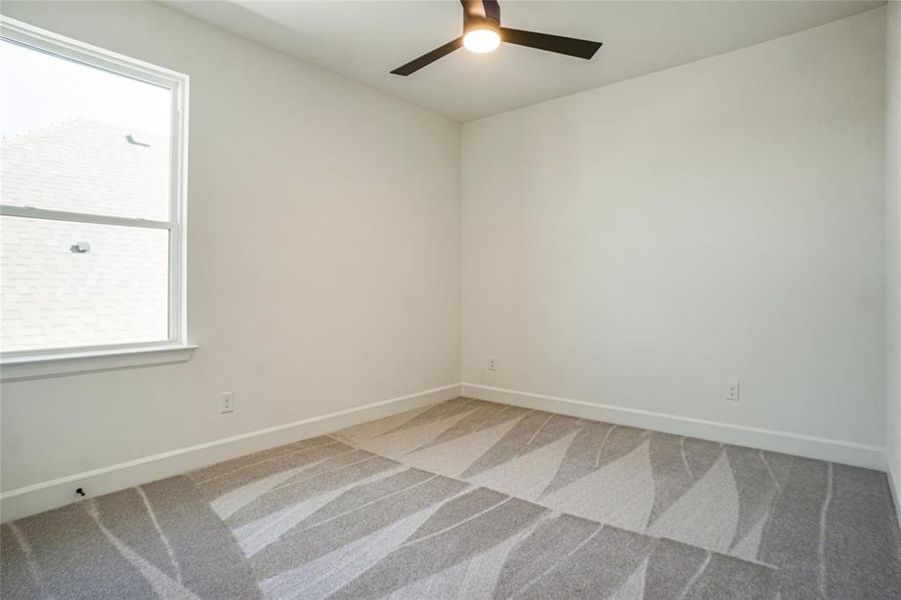 Spare room with light colored carpet and a ceiling fan