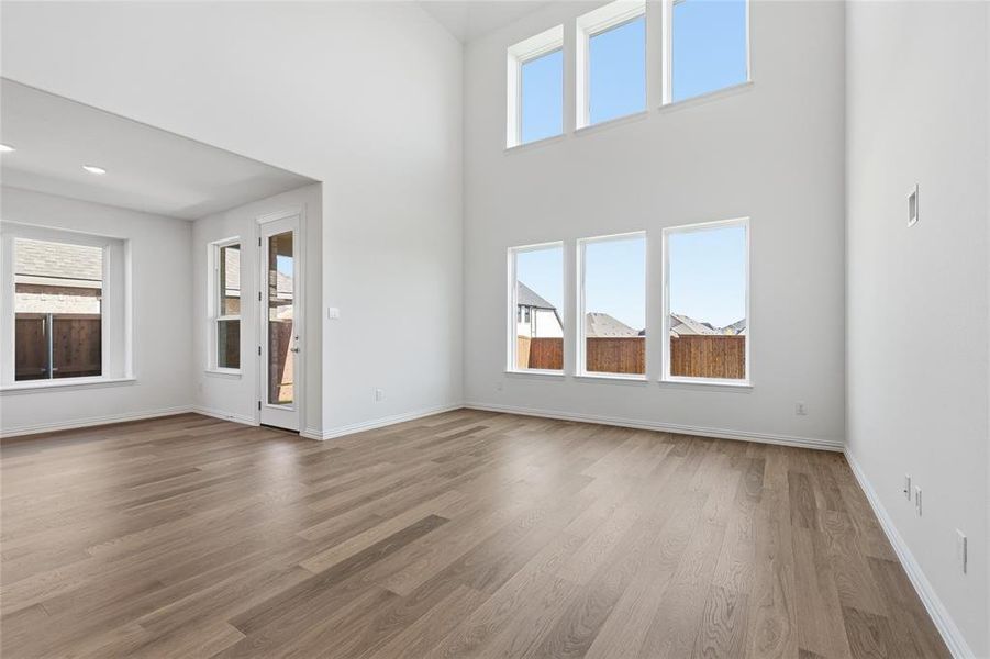 Unfurnished living room featuring dark wood-style floors and a high ceiling