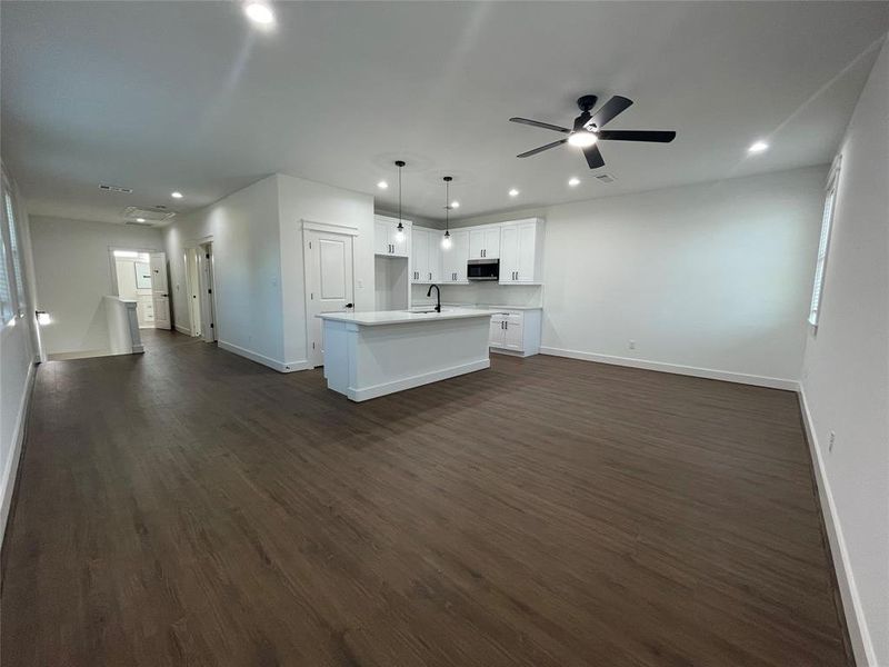 Unfurnished living room featuring recessed lighting, dark wood-type flooring, and a ceiling fan