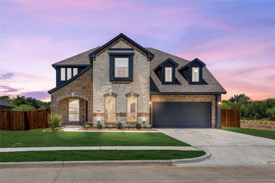 Two-story home with brick and stone exterior, two-car garage, and manicured front lawn Two-story home with brick and stone exterior, two-car garage, and manicured front lawn